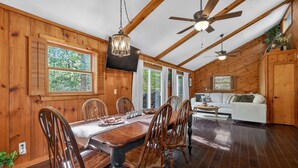 A wooden interior with a dining table, chairs, a sofa, and ceiling fans. - Moneta Memories Lake Retreat | Hot Tub & Fire Pit (Moneta)
