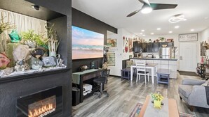 Een moderne woonkamer met een open haard, een eethoek en een keuken.