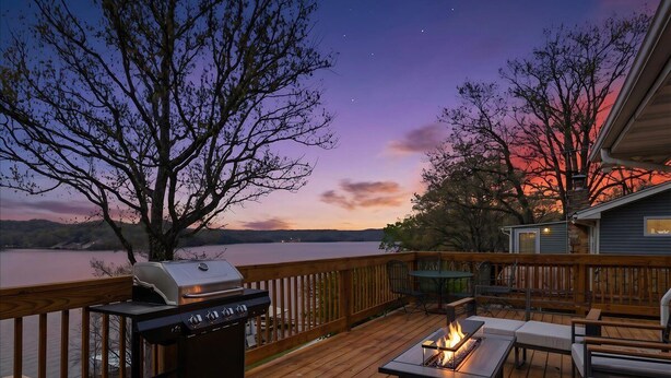A deck with a grill, a fire pit, and outdoor seating. - 46mm Lakefront Home w/ Private Dock, Great Views, Huge Deck & Water Toys (Gravois Mills)