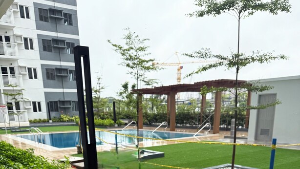 Un pati amb piscina, una pèrgola i un edifici al fons.