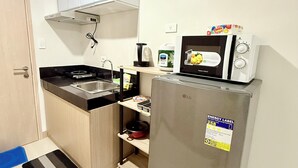 Cuina compacta amb microones, nevera, fogó i rentapelats.