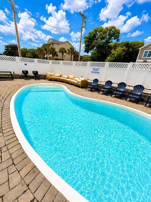 A swimming pool with a white fence, lounge chairs, and a sign indicating shallow water. - Spacious 7 bedrooms duplex walk to the beach+pool (North Myrtle Beach)