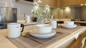 Una cocina moderna con comedor, que incluye una taza blanca, un bol y un florero con flores.
