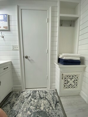 A bathroom with a white door, a sink with a mirror, and a towel rack. - Private 1BR Waterfront Suite Near Siesta Key,Venice Beach & Warm Mineral Springs (Port Charlotte)