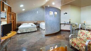 A compact room with a bed, a small desk, a chair, and a sofa. - Hotel privê do Atalaia  (Salinópolis)