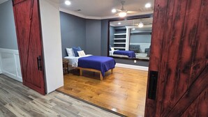 A bedroom with a bed, a wardrobe, a mirror, and a ceiling fan. -  Spacious Private Suite in Gainesville • Separate Entrance • WiFi • Washer/Dryer (Gainesville)