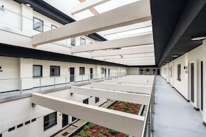 A multi-level hotel atrium with a central open space, balconies, and a view of the sky. - Stylish 1BR Flat in Hull City Centre (Hull)