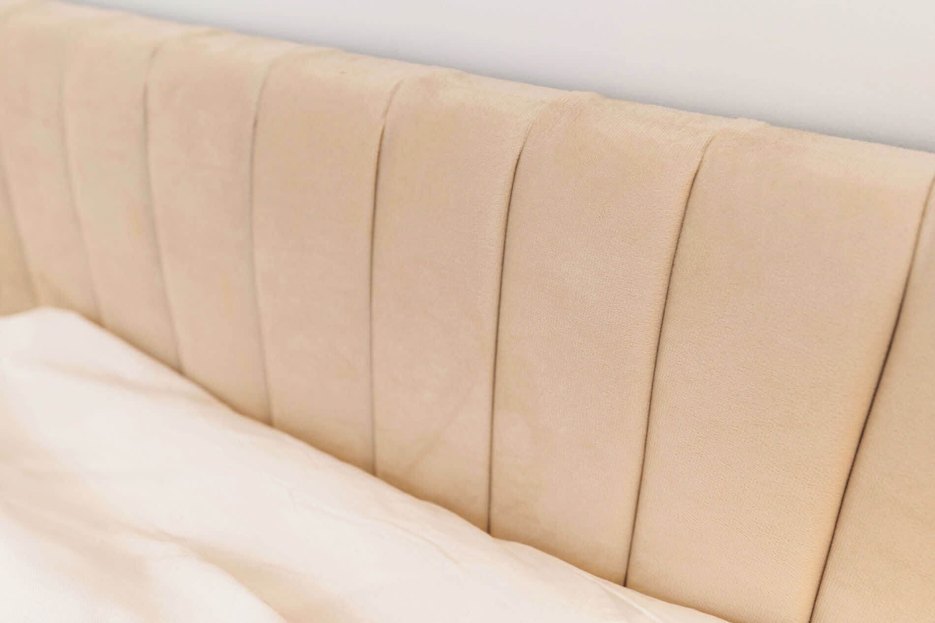 A close-up of a headboard with a smooth, padded surface.