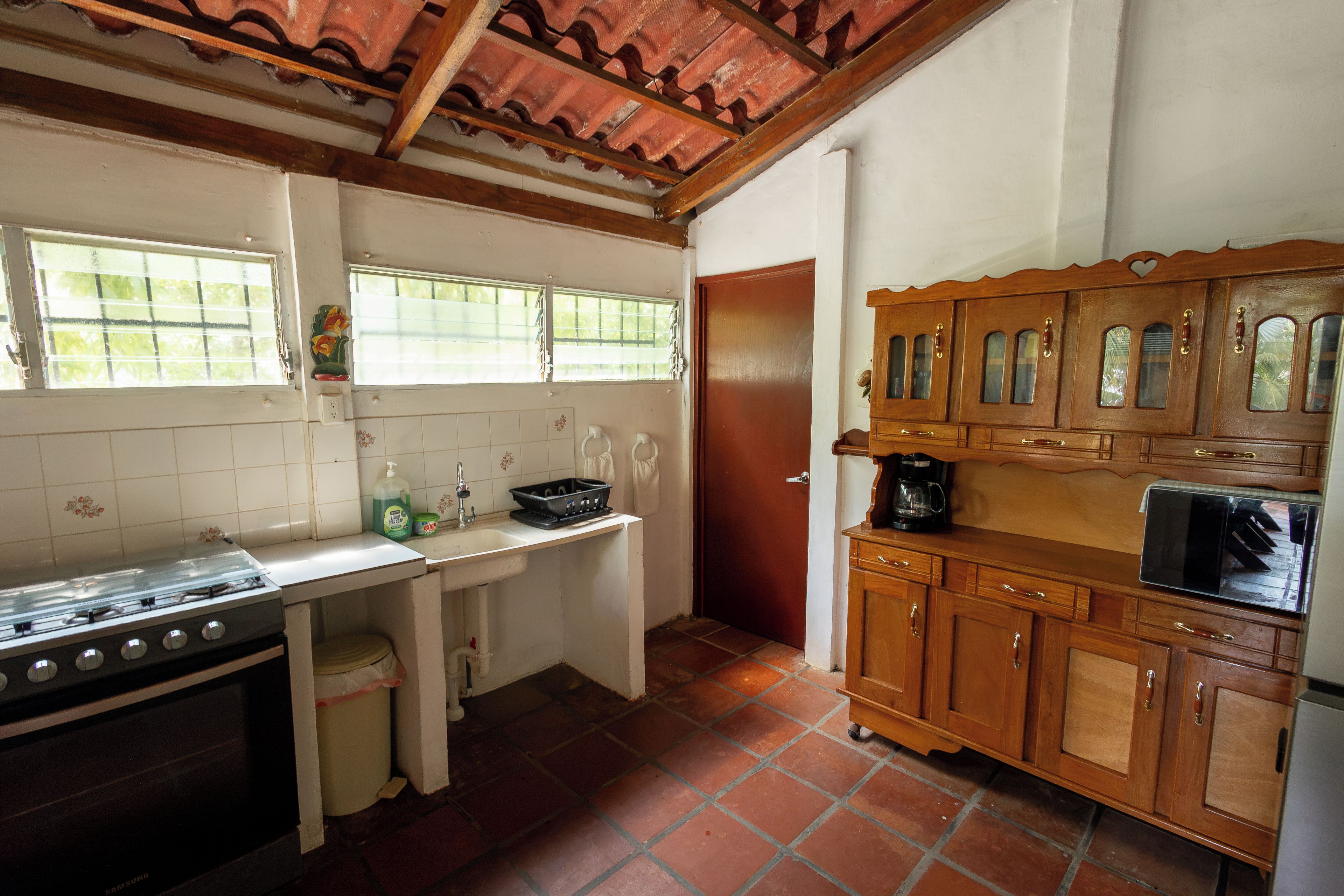 Una cocina con estufa, lavaplatos y armarios de madera.
