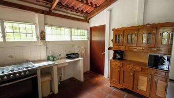 Una cocina con estufa, lavaplatos y armarios de madera.