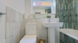 A bathroom with a toilet, sink, and bathtub.