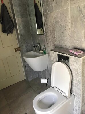 Un baño con inodoro, bidé y lavamanos.
