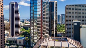 Panorama urbano con moderni grattacieli, tra cui un caratteristico grattacielo curvo e un edificio rettangolare slanciato.