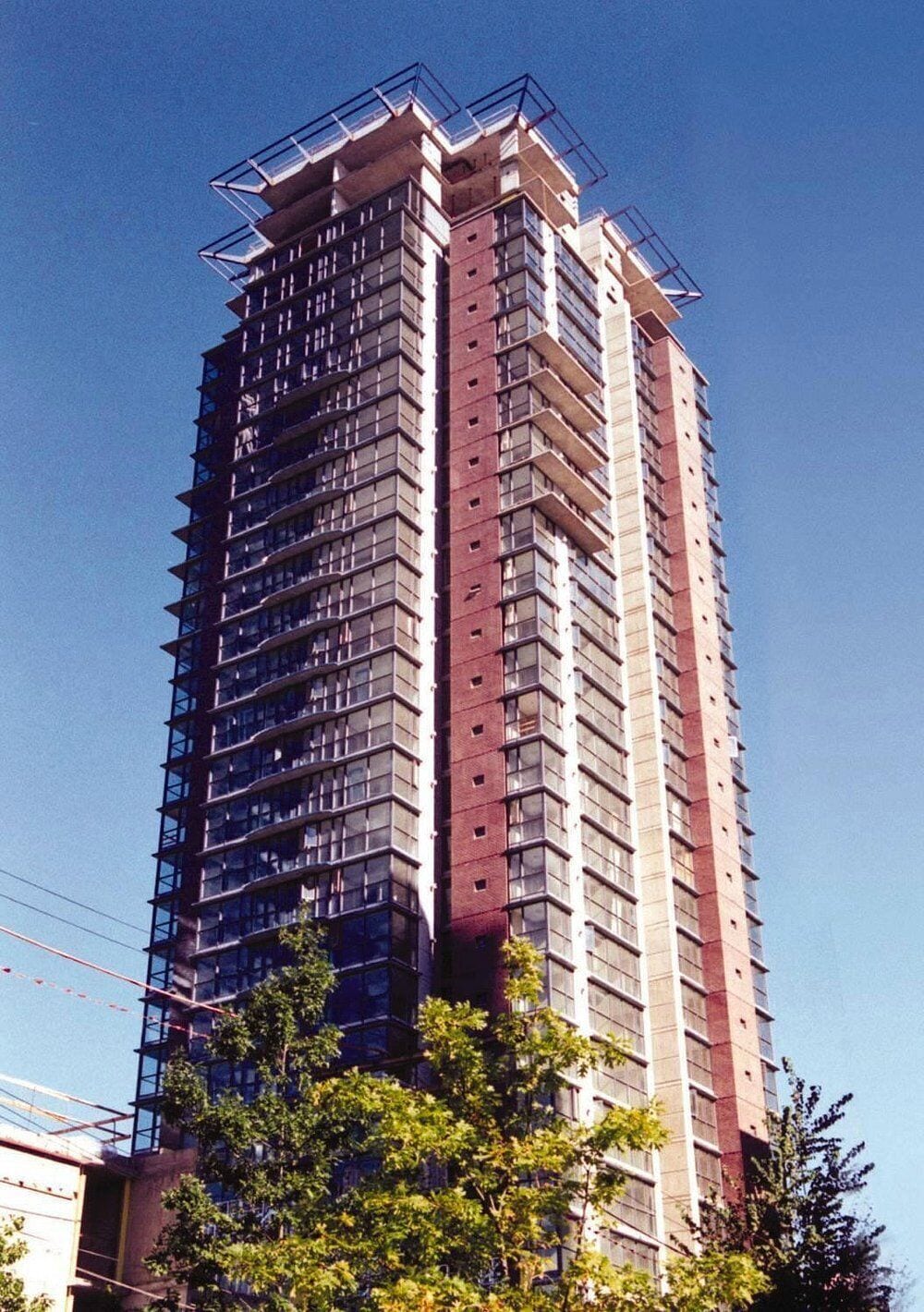 Een hoog gebouw met meerdere verdiepingen, grote ramen en een gevel die doet denken aan een bouwplaats.