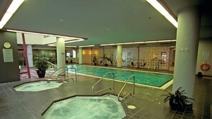 An indoor swimming pool with a tiled floor, a hot tub, and a pool ladder. - Vancouver | Urban Group Retreat | Walkable + Sauna | 2BR (Vancouver)