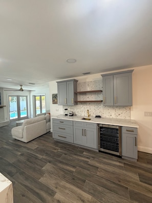 A modern kitchen with grey cabinets, a marble countertop, and a built-in dishwasher. - Peaceful 3-bedroom house with AC in sunny Tampa (Tampa)