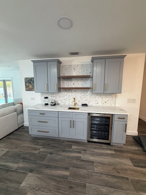 A modern kitchen with grey cabinets, a marble countertop, and a dishwasher. - Peaceful 3-bedroom house with AC in sunny Tampa (Tampa)