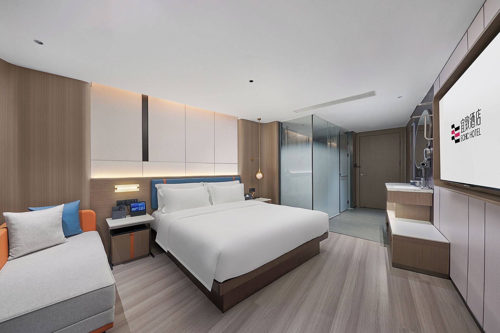 Una habitación de hotel moderna con una cama grande, un escritorio con computadora, cabina de ducha de vidrio y un minibar.