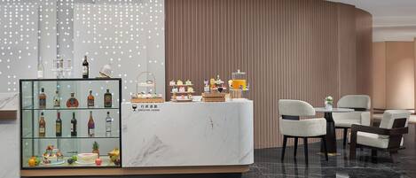 Elegante sala de estar ejecutiva con una vitrina de bebidas, un mostrador de recepción de mármol y cómodos asientos.