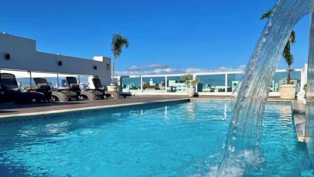 Ein Pool mit Liegestühlen und einem Wasserfall.