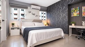 Ein modernes Schlafzimmer mit Bett, Nachttischen, einem Schreibtisch und einer Wand mit einer motivierenden Botschaft.