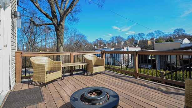 A wooden deck with wicker furniture and a fire pit. - Hidden Nature Haven - Stylish Comfort near Cincy (Park Hills)