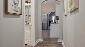 A hallway with wooden flooring, white walls, and a hanging light fixture. - Hidden Nature Haven - Stylish Comfort near Cincy (Park Hills)