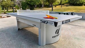 A 510 outdoor table tennis table with a white net and a logo on the side.