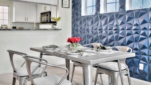 A modern kitchen with white cabinets, a microwave, and a window with a geometric-patterned wall. - Luxurious & Cozy Loft ~ 5 Stars Location - King Bed - Private Patio Retreat (Los Angeles)