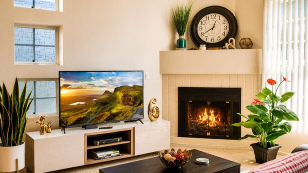 A living room with a TV, fireplace, and decorative items. - Luxurious & Cozy Loft ~ 5 Stars Location - King Bed - Private Patio Retreat (Los Angeles)