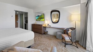 Ein Hotelzimmer mit Bett, Schreibtisch, Stuhl und Fernseher.