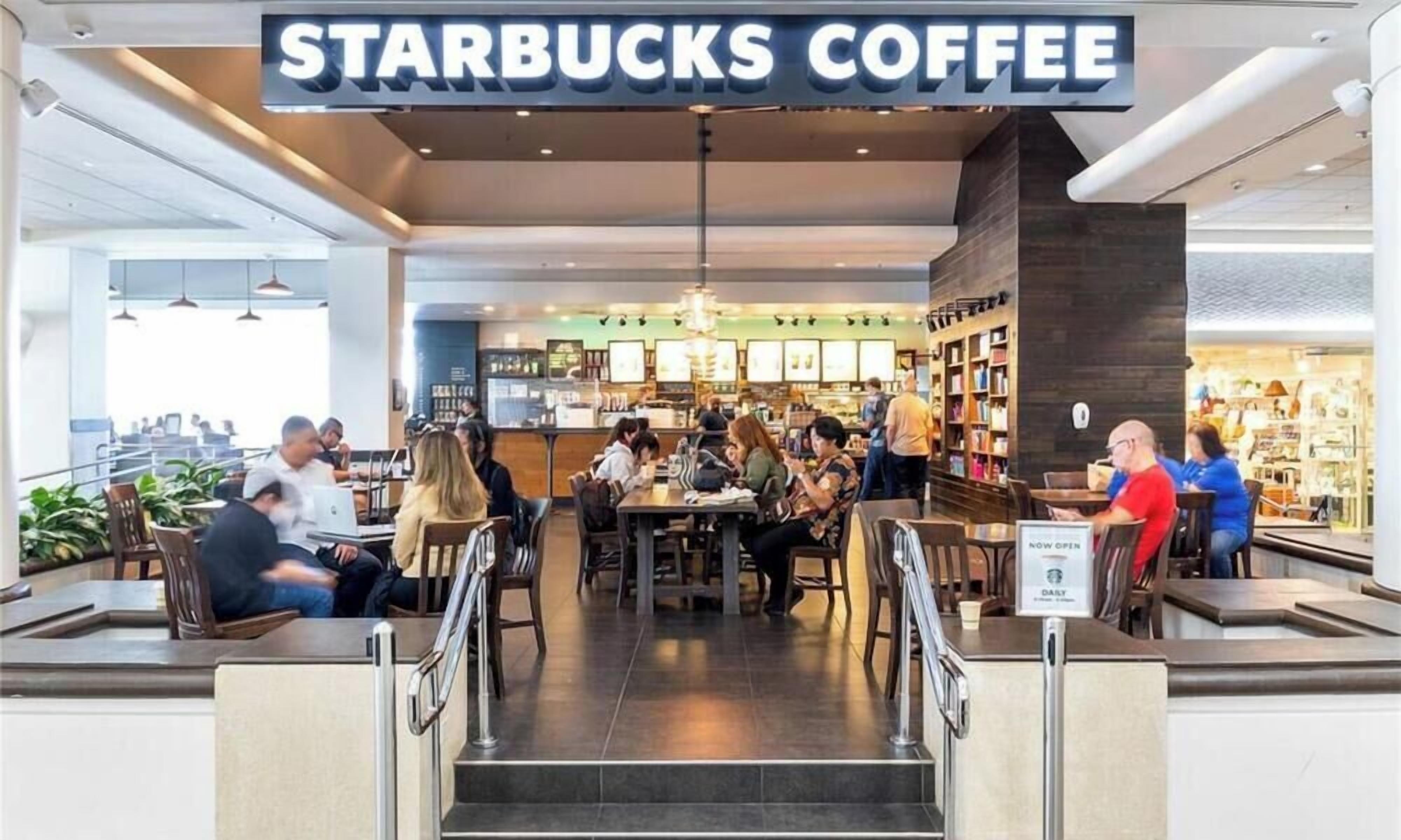 A Starbucks Coffee with indoor seating and a view of the cityscape.