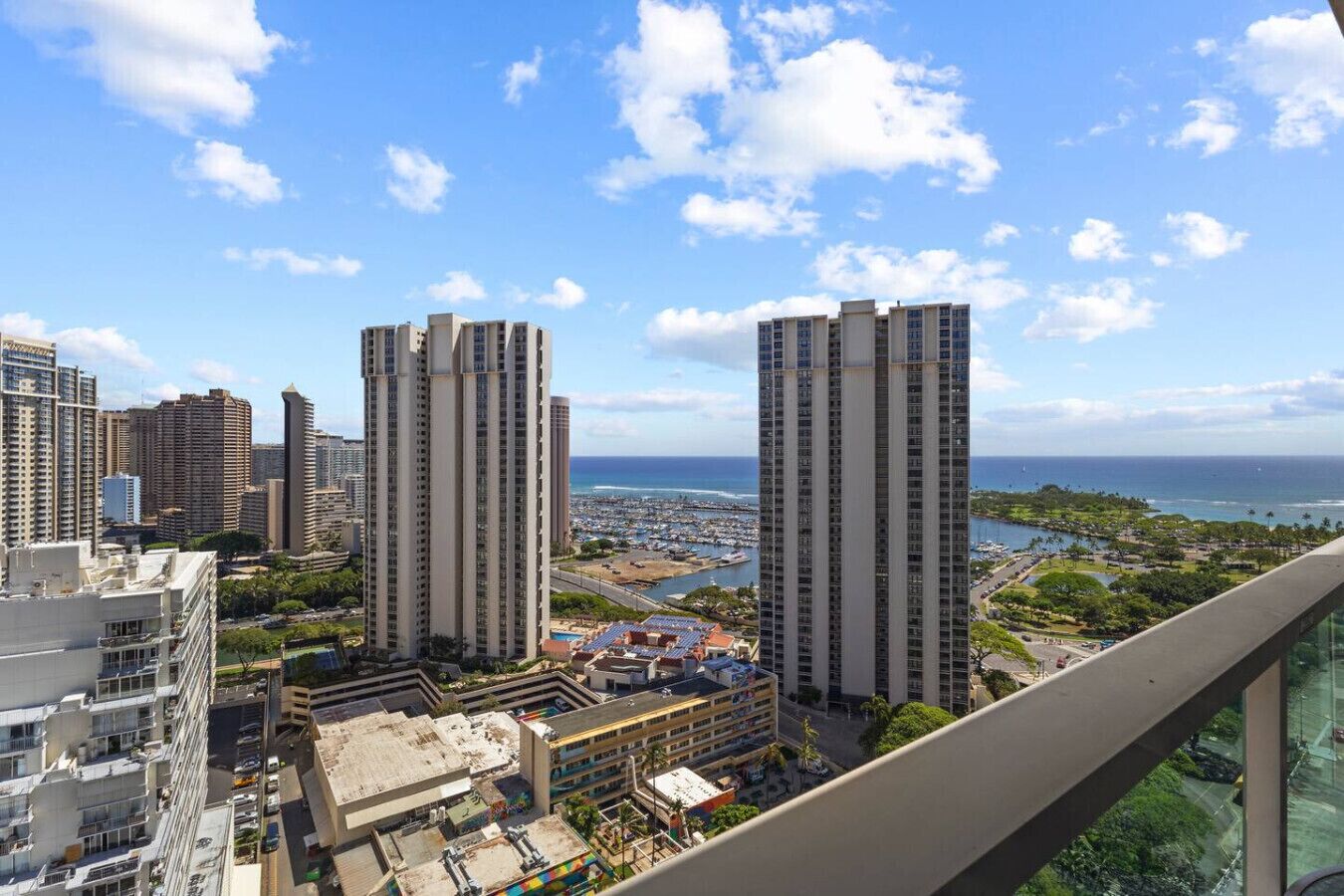 A high-rise building with a view of the ocean and a marina.