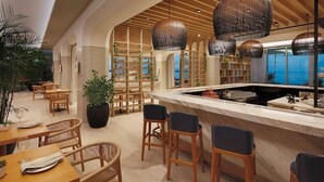Een restaurant met houten meubels, een bar en uitzicht op zee.