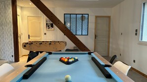 A pool table with a cue ball and a rack of billiard balls, a foosball table, and a billiard table with a wooden frame. - BoiKlo - Heated pool/Billard/Nordic spa 10p (Mesnils-sur-Iton)