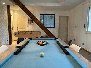A pool table with a cue ball and a rack of billiard balls, a foosball table, and a billiard table with a wooden frame. - BoiKlo - Heated pool/Billard/Nordic spa 10p (Mesnils-sur-Iton)