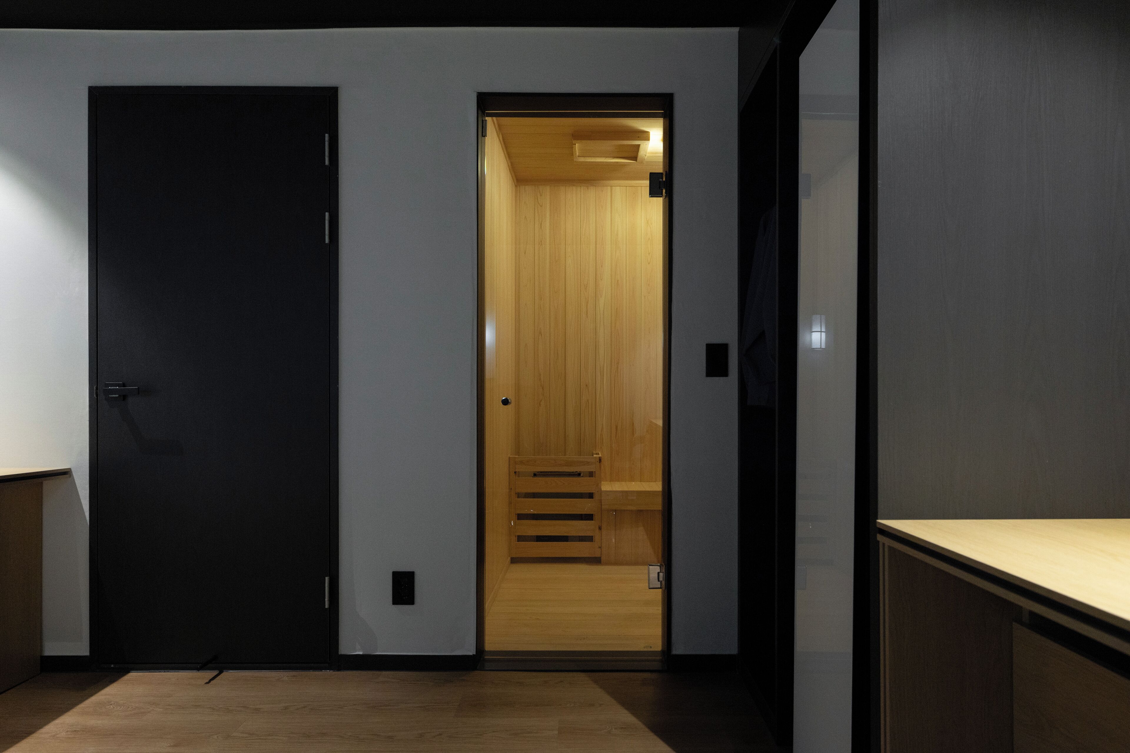 A room with a wooden door, a small wooden staircase, and a light fixture on the ceiling.
