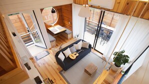 A modern interior with a sofa, guitar, and potted plant. - Cabin Box Huasca (HUASCA DE OCAMPO)
