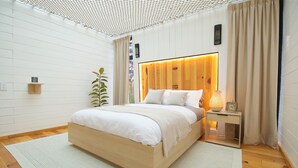 A modern bedroom with a wooden bed, a bedside table with a lamp, and a small shelf. - Cabin Box Huasca (HUASCA DE OCAMPO)
