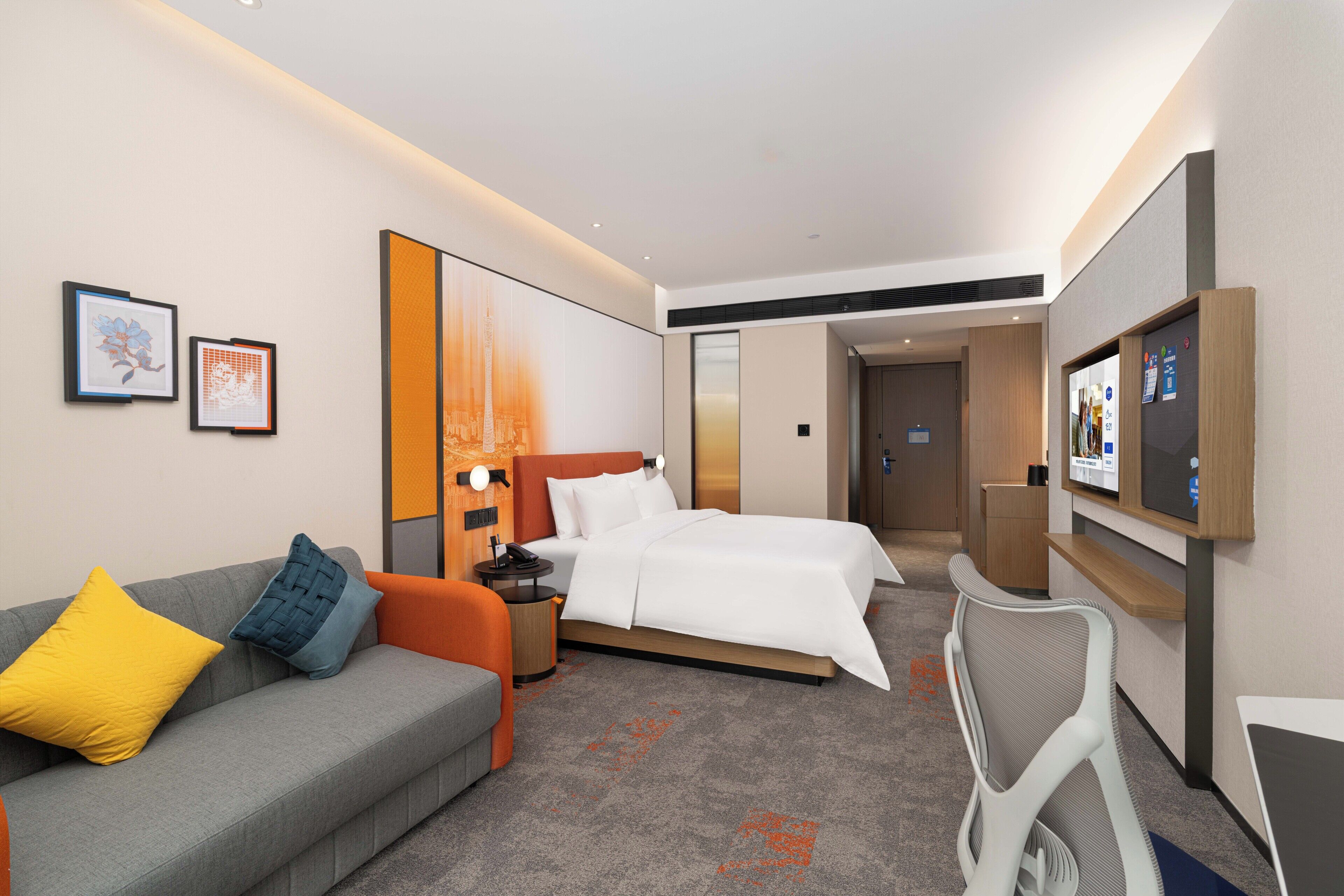 Una habitación de hotel con cama, sofá, escritorio y televisión.