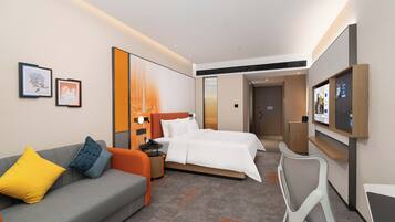 Una habitación de hotel con cama, sofá, escritorio y televisión.