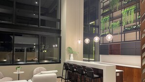 Un interior moderno con una zona de bar, asientos y ventanas amplias.