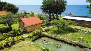 A coastal property with a small wooden building, a paved area, and a water channel.