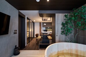 A modern interior with a dining area, kitchen, and a large wooden bath tub. - Loop Seoul Hotel by Anook Seoul Gangnam 2 (Seoul)