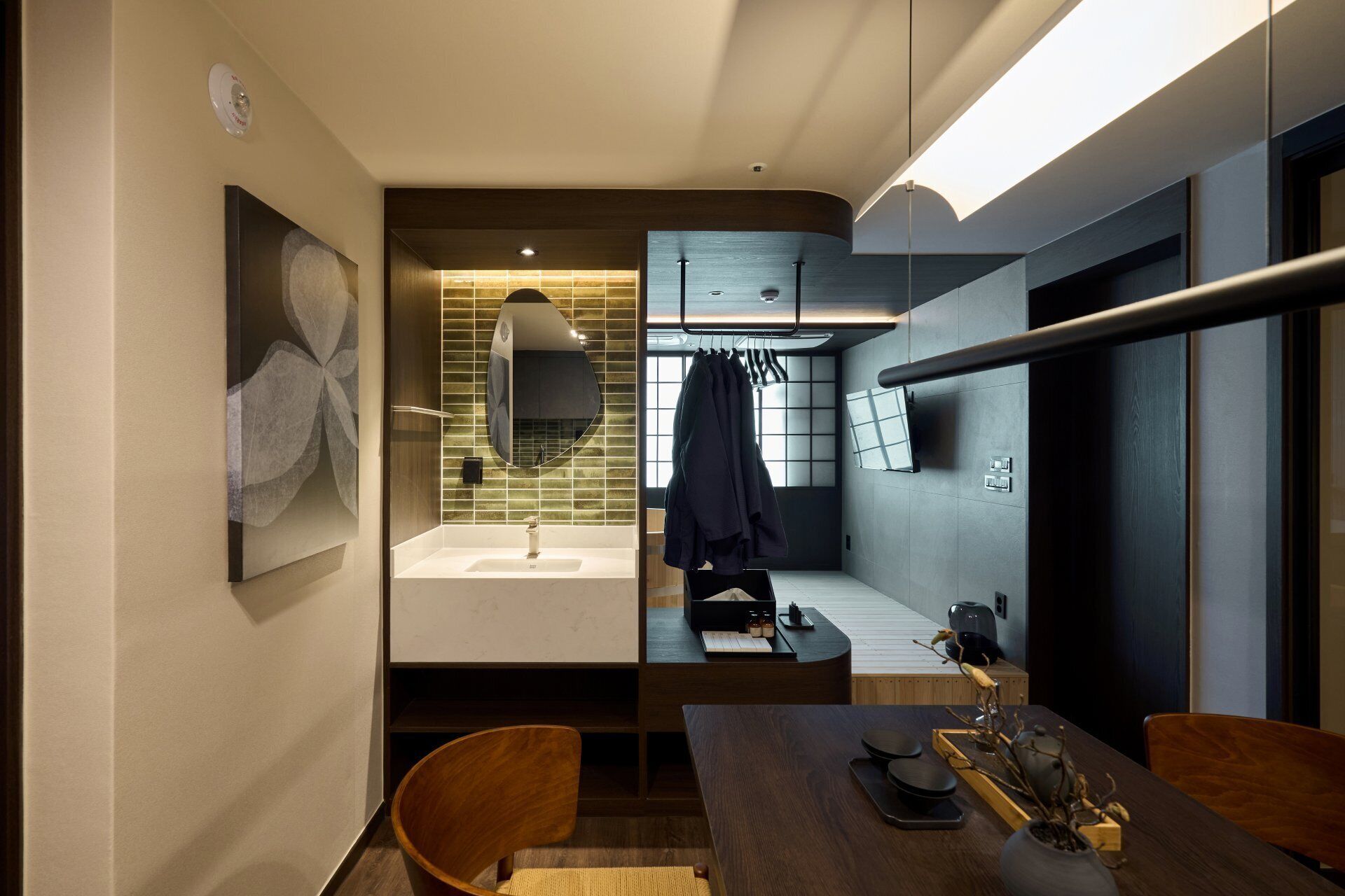 Uma casa de banho moderna com lavatório, espelho e porta-toalhas.