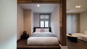 Una camera d'albergo moderna con un letto, un comodino e vista sulla città.