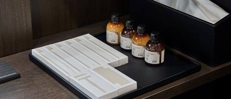 A wooden table with a black tray holding several small bottles labeled 'Lavender' and a white box with compartments.