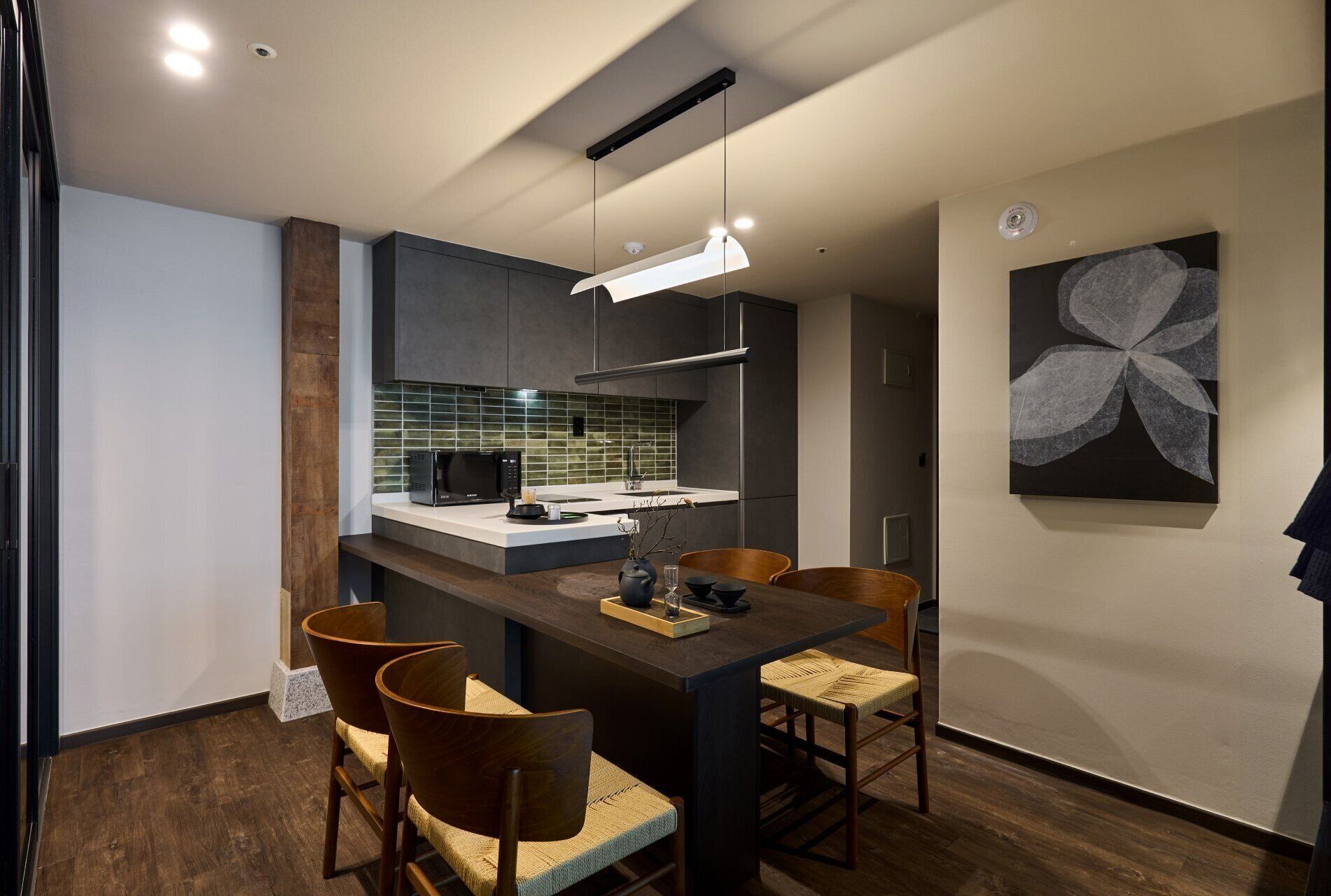 A modern kitchen with a built-in microwave, a coffee machine, and a small island with seating.