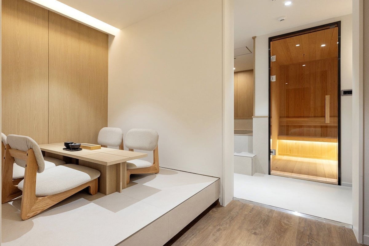 Un comedor moderno con pared de madera, una mesa y dos sillas.