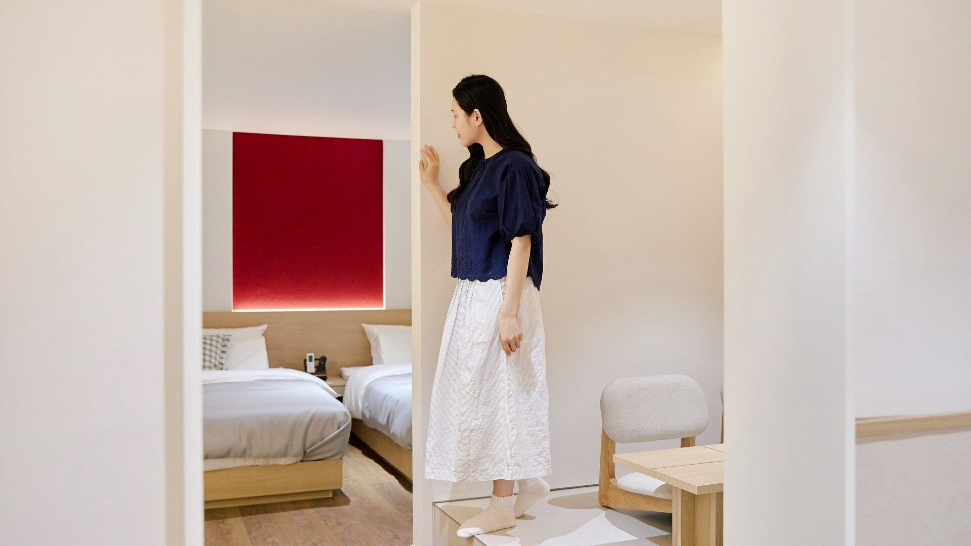 Quarto de hotel com cama, secretária e cadeira.